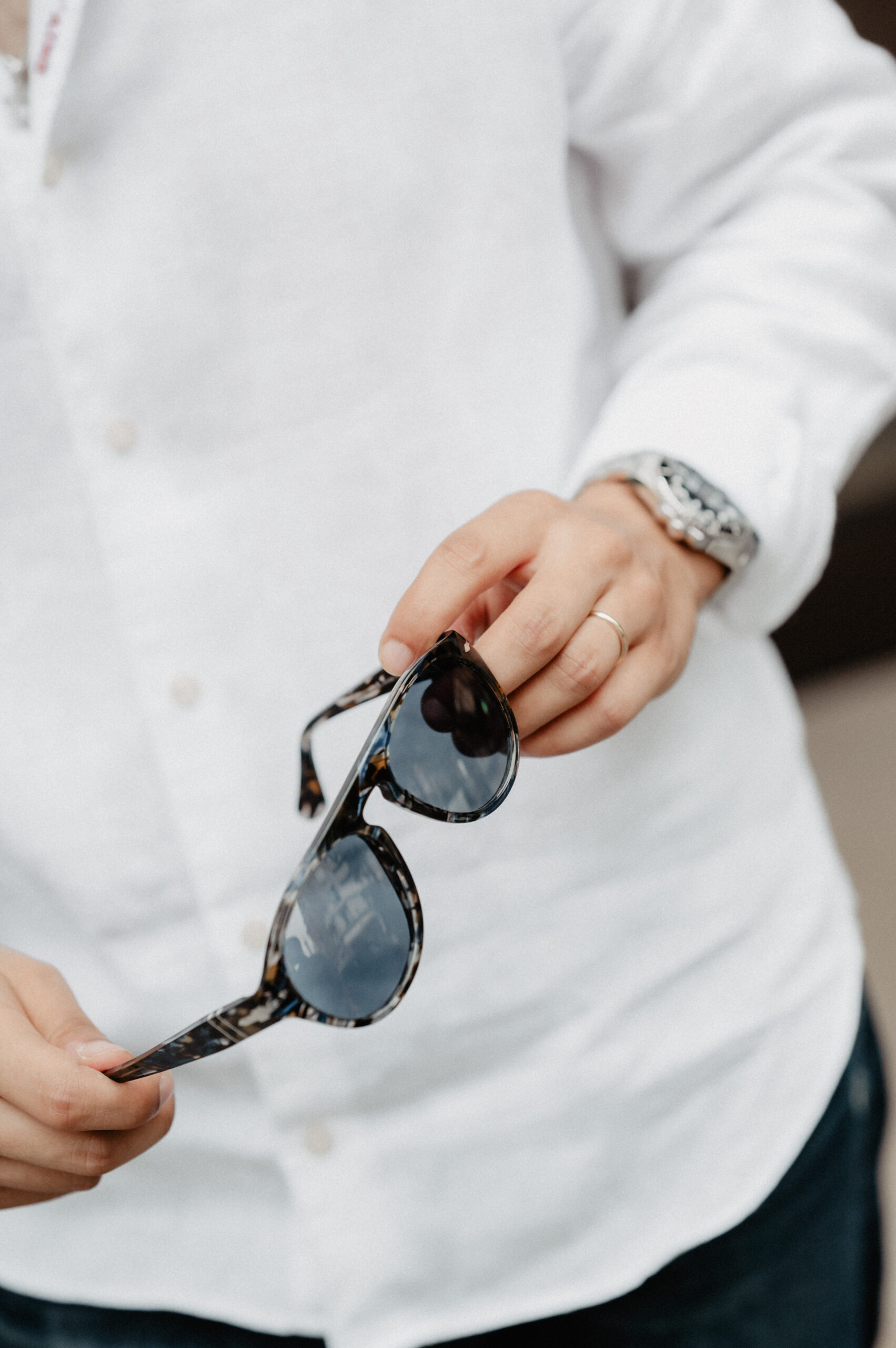 Main tenant une paire de lunettes Persol – opticien de luxe Paris 16.