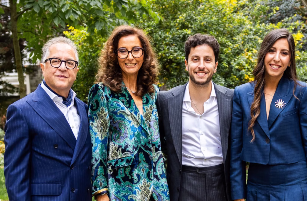 Famille propriétaire d’Optique Gualdoni à Paris posant dans un jardin, illustrant la maison familiale et son héritage artisanal depuis 1901.